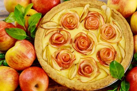 Close uo of apple pie with rose shape apple decorated and fresh apples. Stock Photos