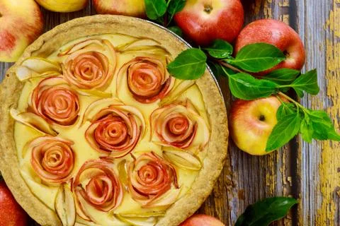 Close uo of cheesecake with rose shape apple decorated and fresh apples. Stock Photos