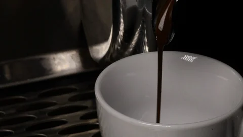 Close-ups of the coffee jet, which is poured into a cup from a coffee espresso Stock Footage 116362124