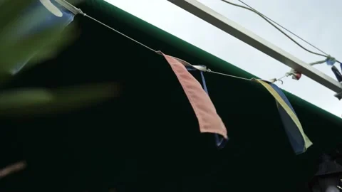 Close-ups of colored fabric carnival flags hanging on a rope and rattling from Stock Footage 196187720