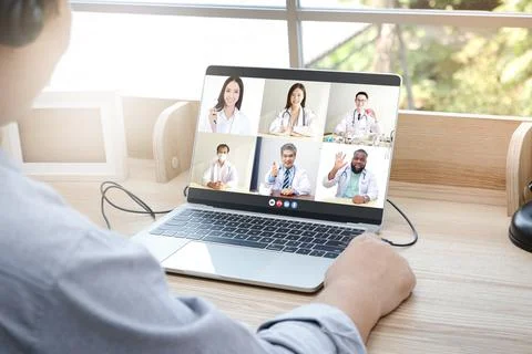 Close-ups on the computer screens a group of doctors greets the patients 库存照片