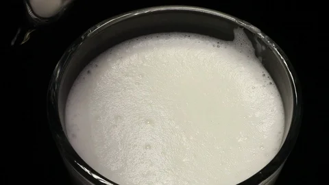 Close-ups on the top of the coffee jet, which is poured into a glass of mocha or Stock Footage 116363768
