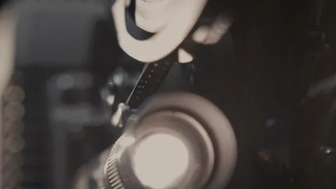 Close ups of a vintage 8MM projector spools moving and playing film Stock Footage 301844382
