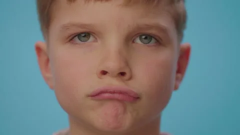 Close up of upset boy showing disappointment standing on blue background Stock Footage 167178445