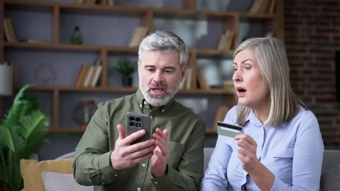 Close up of upset senior married couple facing fraud problem using credit card  Stock Footage 339775445