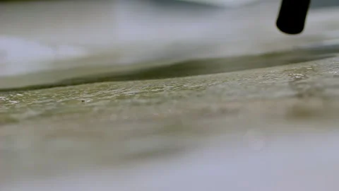 Close-up of urban cleaning action with squeegee sliding over wet pavement Stock-Footage 313868256