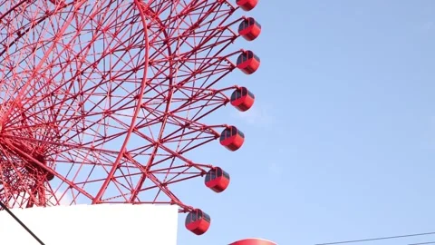 Close urban view of the distinctive red HEP FIVE Ferris Wheel rising above the Stock Footage 346330665
