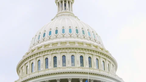 Close-up of the U.S. Capitol dome with American and POW flags flying at half-sta Video stock 310862811