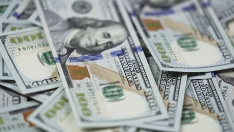Close-up of US dollar banknotes stacked in a disorganized manner, showcasing the Stock Footage 327698903