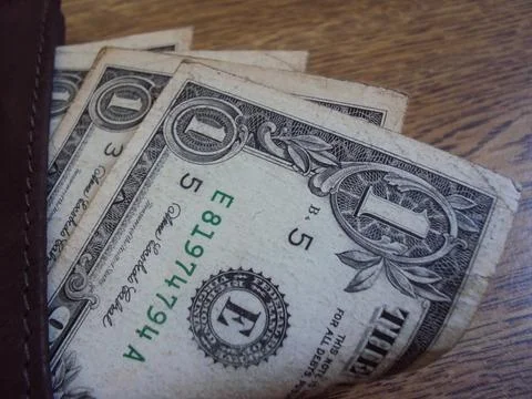 Close-up of US dollar bills inside a leather wallet. Financial transaction or Stock Photos