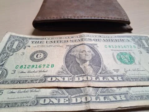 Close-up of US dollar bills on a wallet. Financial transaction or cash handling Stock Photos