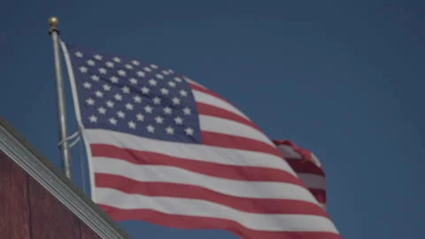 Close-up US flag waving on building rooftop 库存影片 336671877