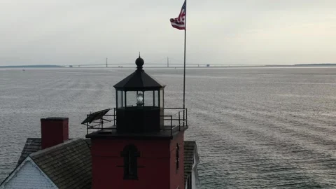 Close up USA Flag on Top Lighthouse with Bridge in Background Stock Footage 246930578