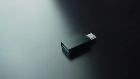 Close-up of a USB 3.0 to USB-C adapter on a dark desk with soft bokeh and copy Видео 331563432