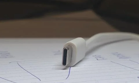 Close-up of a USB-C cable connector on a notepad, showcasing modern technology Stock Photos