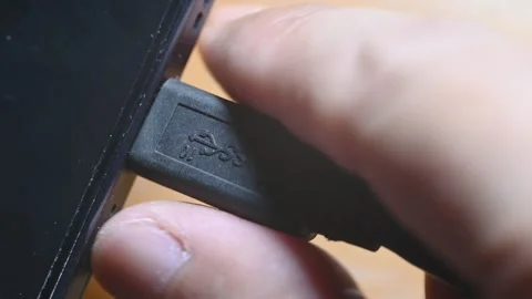 Close-up of USB-C cable plugging and unplugging into smartphone charging port Stock Footage 345506123