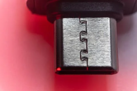 Close-up of a USB-C connector with red lighting. Stock Photos