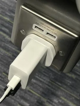 Close-Up of USB Charger Plug with Device Plugged In in Public Socket Stock Photos