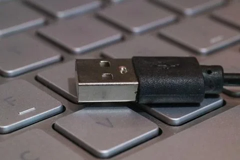 Close up of usb data cable above keyboard Stock Photos