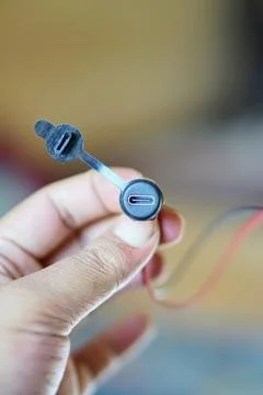 Close-up of a USB Type-C connector with a rubber protective cap held in hand Stock Photos