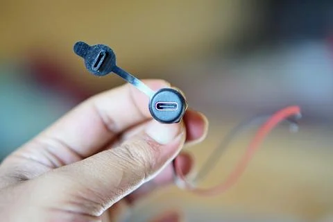 Close-up of a USB Type-C connector with a rubber protective cap held in hand Stock Photos