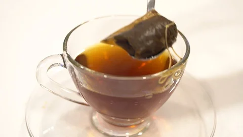 Close up use spoon take tea bag out from the cup glass Stock Footage 109560599