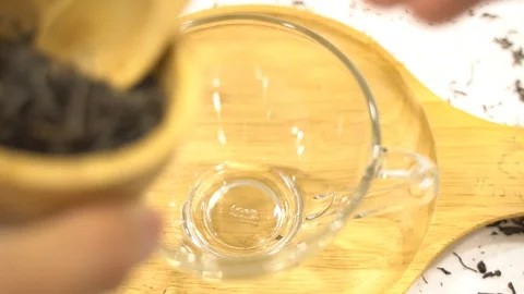 Close up use wooden spoon put tea leaves to a cup glass Stock Footage 110897520