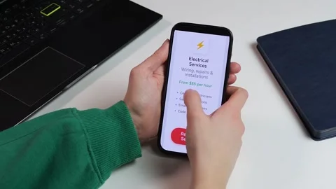 Close-up of a user booking professional electrical services via a mobile app Stock Footage 327672117