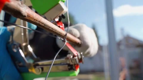 Close-up of using a garden stapler to tie up grape vines Stock Footage 307813511