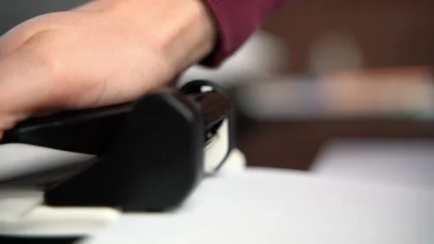 Close up of using a hole puncher in office, documents Stock Footage 159543885