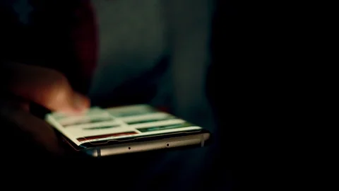 Close up of Using smart phone in the dark. Hand scrolling on screen browsing and Stock Footage 114229918