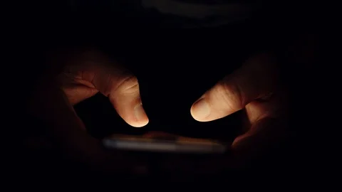 Close up of Using smart phone in the dark. Hand scrolling on screen browsing and Stock Footage