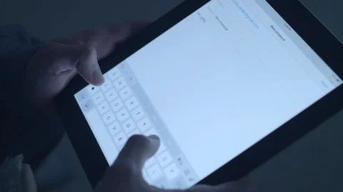 Close up using a tablet in the dark from an angle. Stock Footage 86567632