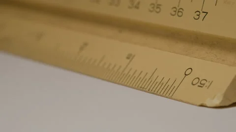 Close up of using a triangular scale ruler with pencil on white paper draw ar Video stock 132547554