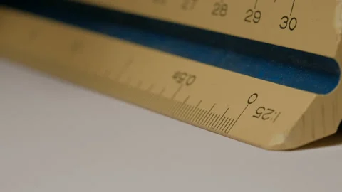 Close up of using a triangular scale ruler with pencil on white paper draw ar Video stock 132547731