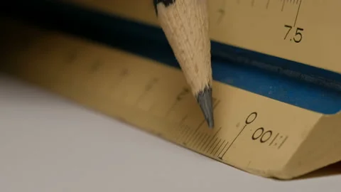 Close up of using a triangular scale ruler with pencil on white paper draw ar Video stock 132547820
