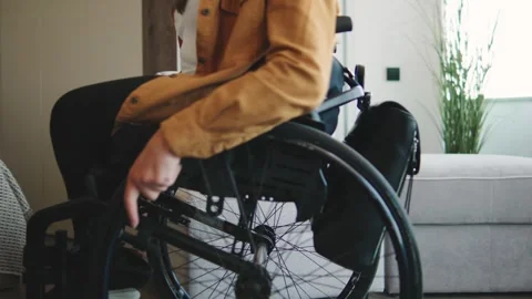 Close up of using a wheelchair for daily mobility and independence in a modern Stock Footage 320504413