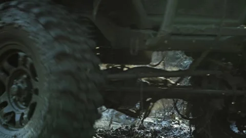Close-up of a utility vehicle racing in mud. The spinning tire splashes dirt Stock Footage 344876382