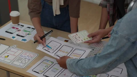 Close up ux developer and ui designer brainstorming interface wireframe design Stock Footage 243427005