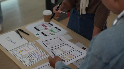 Close up ux developer and ui designer brainstorming interface wireframe design Stock Footage 243617252