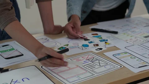 Close up ux developer and ui designer brainstorming interface wireframe design Stock Footage 243728257