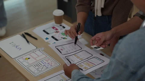 Close up ux developer and ui designer brainstorming interface wireframe design Stock Footage 243976728