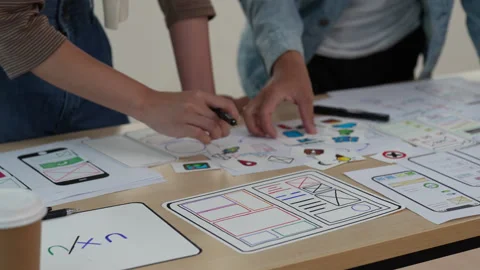 Close up ux developer and ui designer brainstorming interface wireframe design Stock Footage 243977100