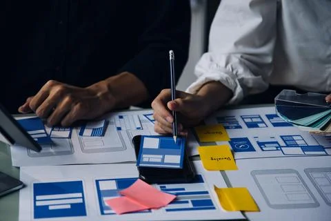 Close up ux developer and ui designer brainstorming about mobile app interf.. Stock Photos