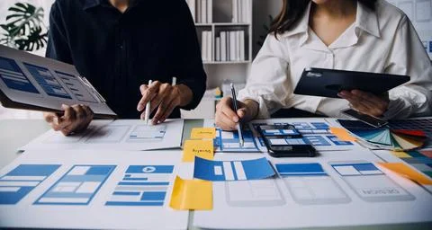 Close up ux developer and ui designer brainstorming about mobile app interf.. Stock Photos