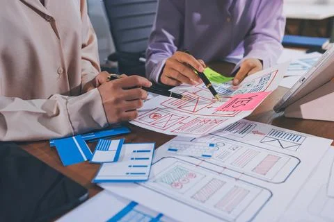 Close up ux developer and ui designer brainstorming about mobile app interf.. Stock Photos