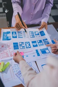 Close up ux developer and ui designer brainstorming about mobile app interf.. Stock Photos