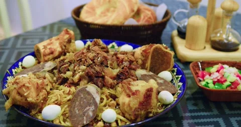 Close-up of Uzbek plov served on table with meat, kazy, quail eggs and raisins Stock Footage 329667909