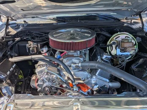 Up-close V8 engine with polished silver supercharger gleaming in sunlight Stock Photos