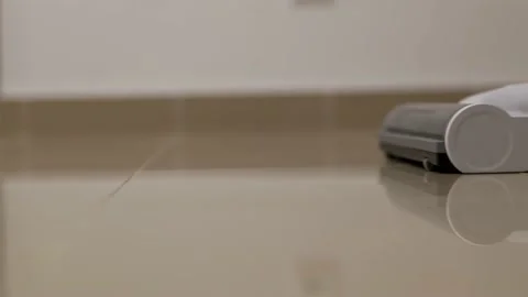 Close-up of a vacuum cleaner brush during cleaning. A woman or a man vacuums the Stock Footage 202010064